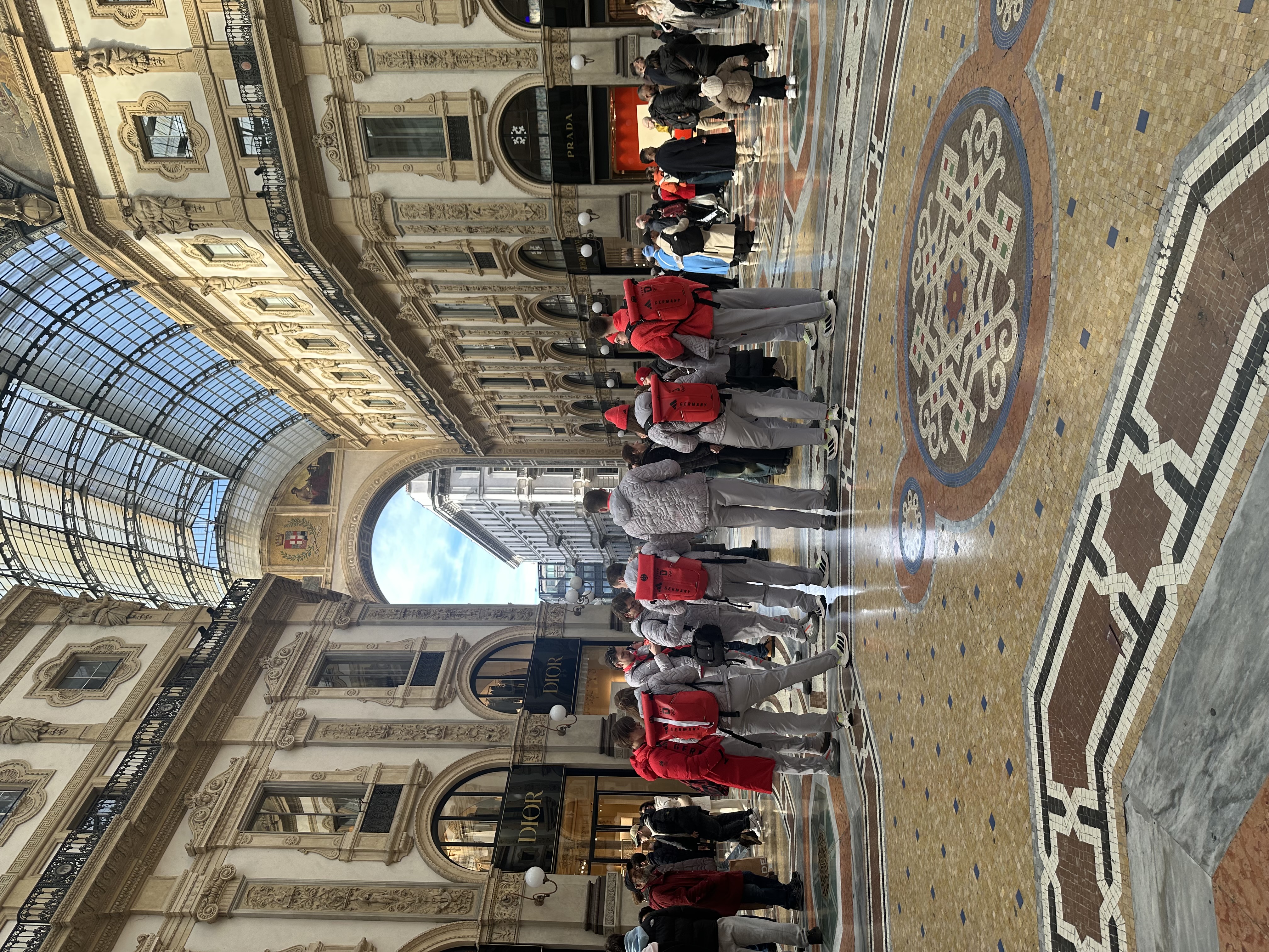 Athletes in red uniforms at Galleria Vittorio Emanuele II