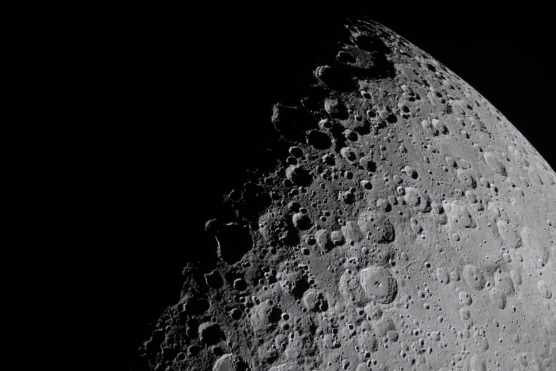 The Moon's terminator — the boundary between lunar day and night — with dramatic long shadows cast across craters and ridges