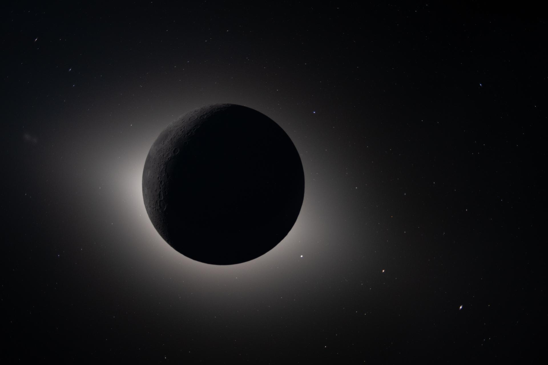 The Moon completely eclipsing the Sun as seen by the Artemis II crew — a glowing halo surrounds the dark lunar disk, and stars are visible in the surrounding darkness